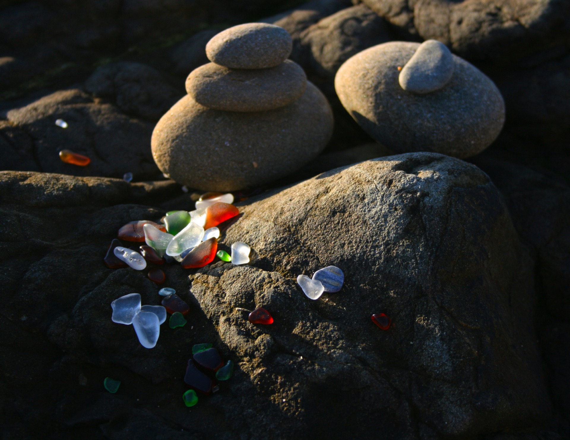 Frosted sea glass among the stones at Glass Beach at dusk